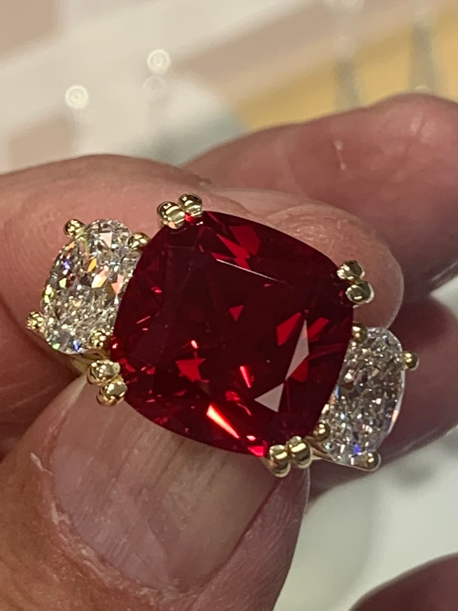 Cushion-cut ruby with two cushion diamond side stones
